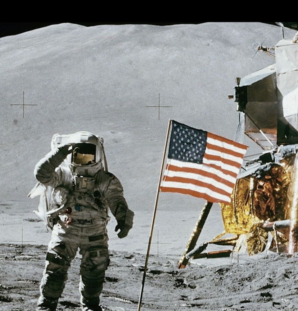 Astronaut on the moon standing next to united states flag
