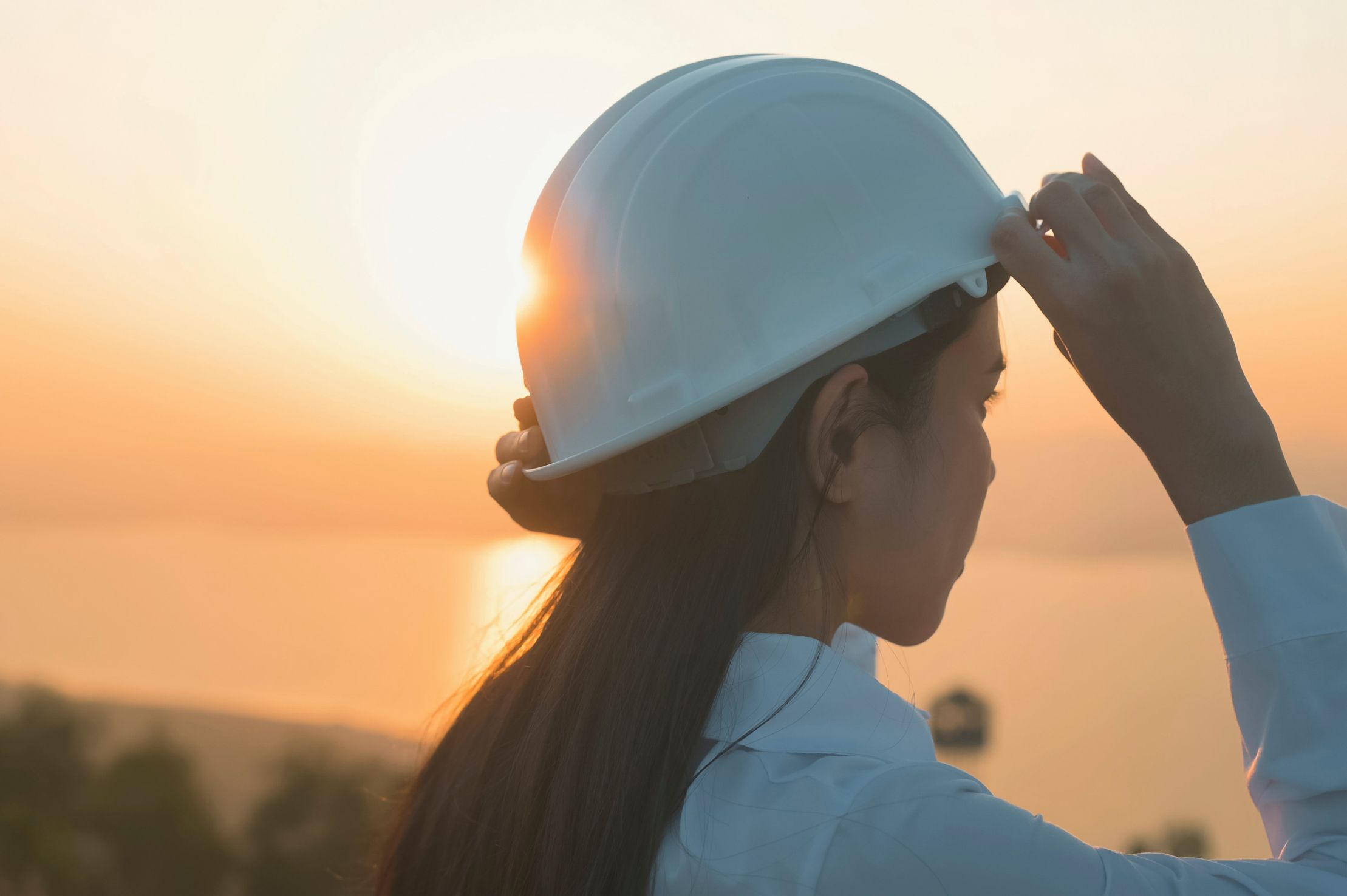 Woman wearing a hard hat looking in the distance